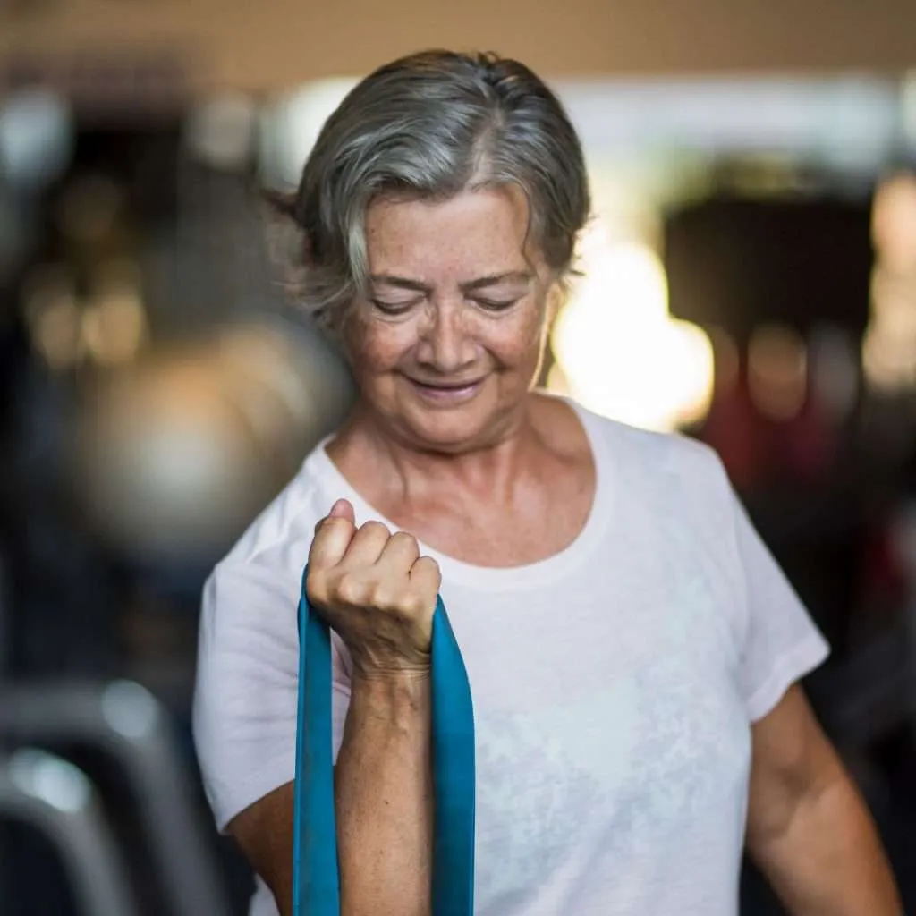 Older woman doing strength training with a resistance band.