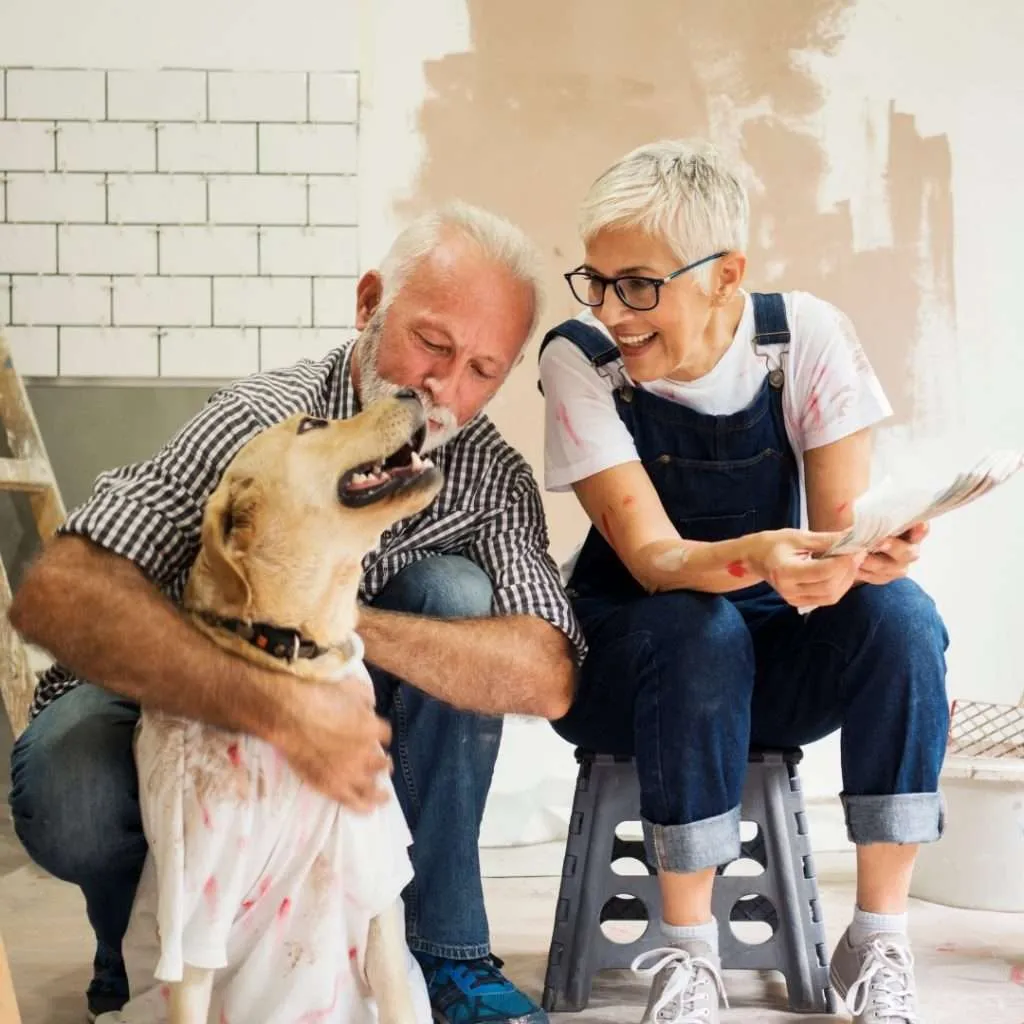 Older couple completing home renovations with their dog.