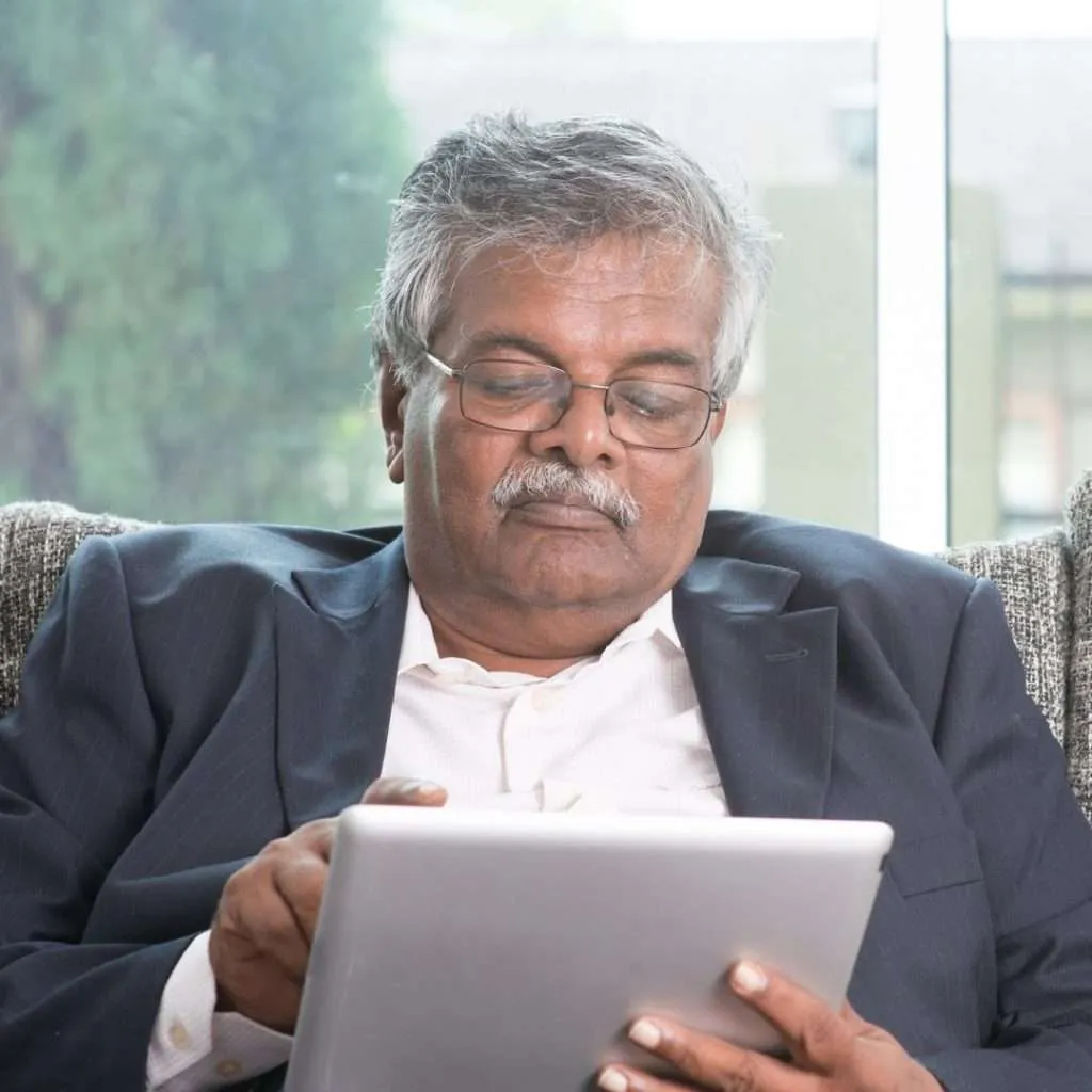 Older man working on a tablet computer.