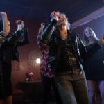 Energetic seniors enjoying a fun dance party in a dimly lit nightclub setting.