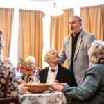 Senior man delivers a heartfelt toast at a cozy family gathering in a restaurant setting.