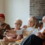 A group of senior adults relaxing and watching TV together in a cozy living room.
